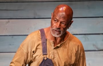 An actor is shown looking stern and serious