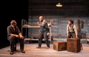 William Young, playing Lennie, Ben Wilson, playing Curley and Liam King playing George look at each other in excitement.