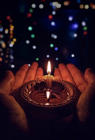 Diwali image - person holding candle in their hands