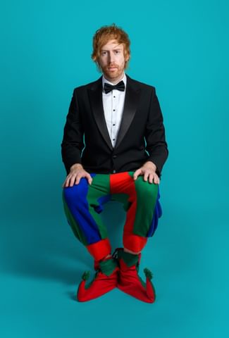 Image of Mark Simmons wearing a suit with clown pants and shoes on