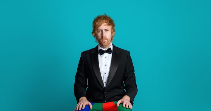 Image of Mark Simmons wearing a suit with clown pants and shoes on