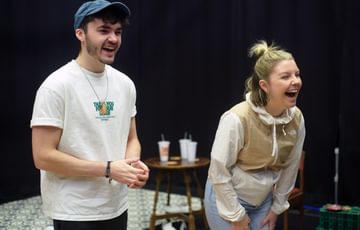 Two actors are shown. Both of them are smiling and laughing.