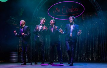 Four men in black suit singing and having fun