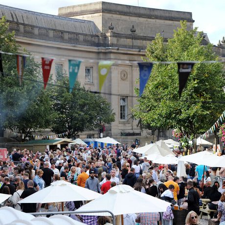 Le Mans Crescent in Bolton Town Centre, filled with a crowd of people and food stalls