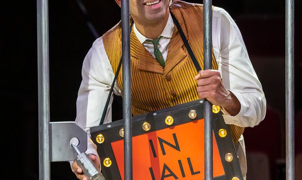 A man trapped behind bars with an orange sign that reads 'In jail'