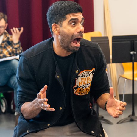 Man crouching with both hands out in front of him with a scared look on his face.