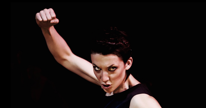 woman holding fist up in air with intense look