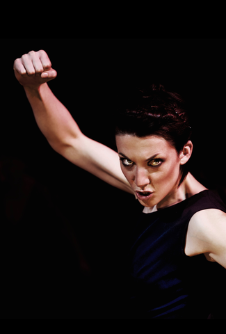 woman holding fist up in air with intense look