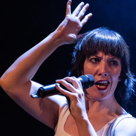 woman with instense look speaking into a mic