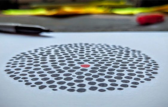 Image of black dots in a circle with a red dot in the middle