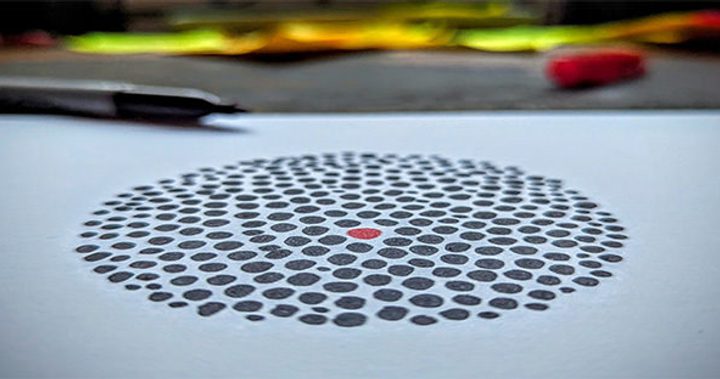 Image of black dots in a circle with a red dot in the middle