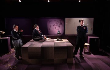 Three women on stage talking