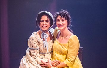 two women sitting next to each other and hugging