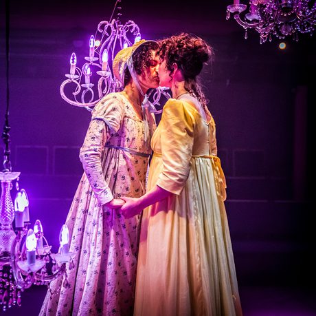 2 women wearing regency clothing kissing