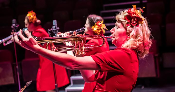 Blonde woman in red dress playing the trumpet