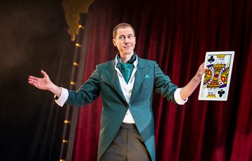 Man holding giant playing card