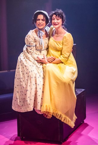two women sitting next to each other and hugging