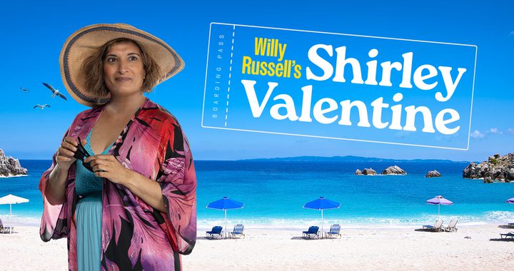 Actor Mina Anwar in a beach outfit with a Greek beach background