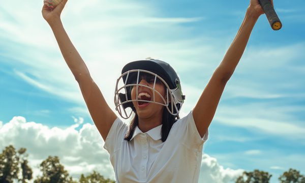 Woman holding a cricket ball and bat