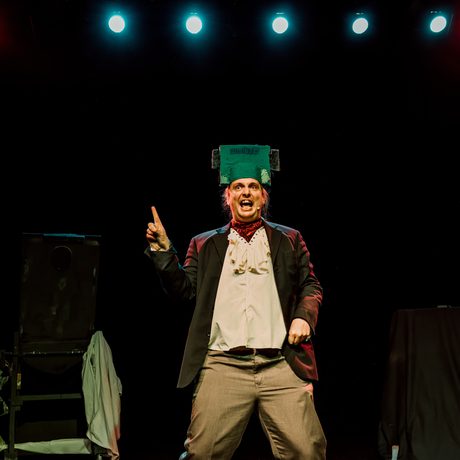 Actor is shown centre stage wearing a Frankenstein inspired head piece