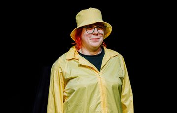 Actor is shown wearing a matching yellow rain hat and jacket