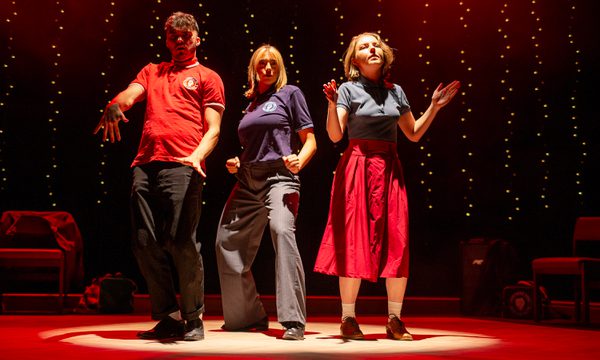Three actors are shown on the stage posing