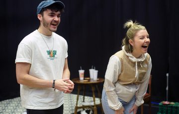 Two actors are shown. Both of them are smiling and laughing.