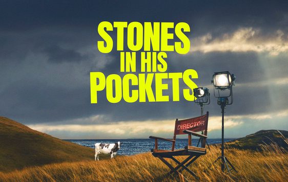 Stones in his pockets title with a director chair in a field and a cow in the background
