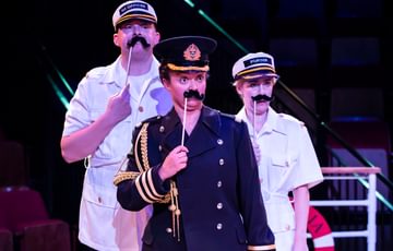 Actors with pretend moustaches looking silly