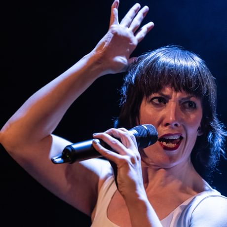 woman with instense look speaking into a mic