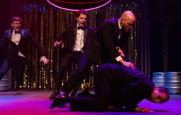A man has grab another man arm behind his back and has him on the floor, with anther two men running towards them