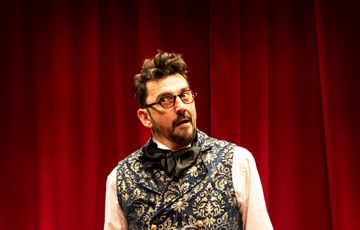 Van Helsing in front of red curtain