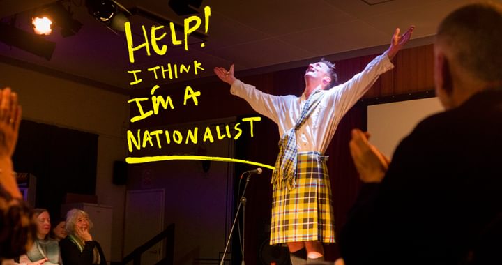 man in kilt with arms aloft.