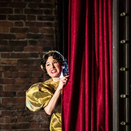 Woman looking from behind a curtain