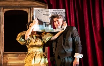 Man looking through hole in newspaper