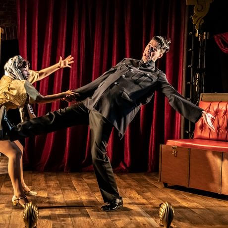 Man falling over and woman trying to stop him