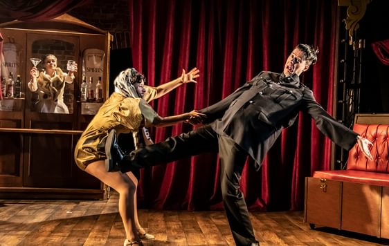 Man falling over and woman trying to stop him