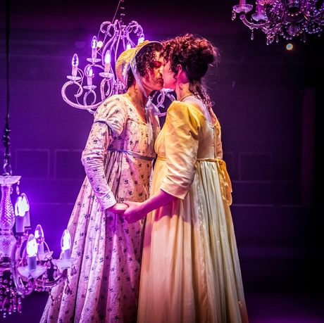 2 women wearing regency clothing kissing