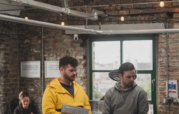 Two men stood up, one with script in hand