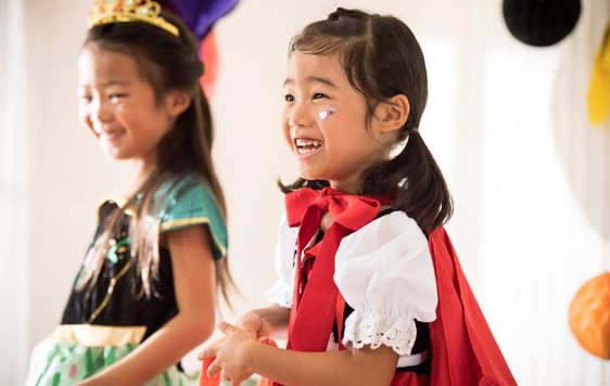 2 small children in costumes smiling