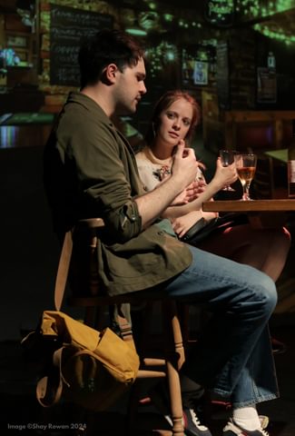 Image of a man and woman  sat at a table on bar stools