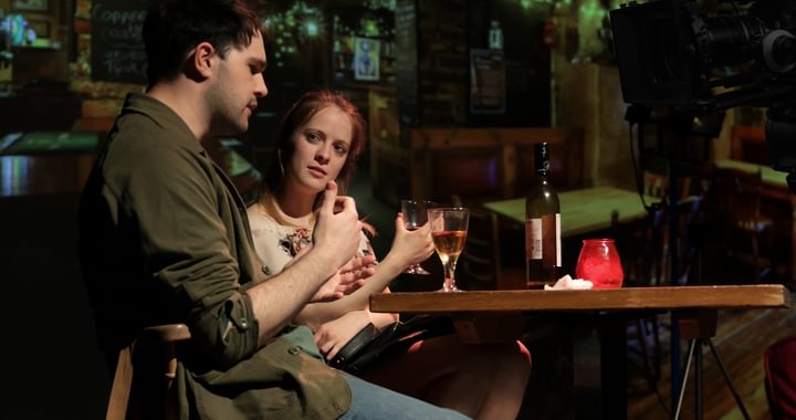 Image of a man and woman  sat at a table on bar stools